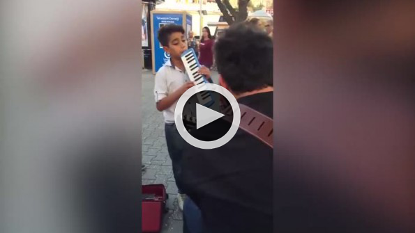 Sokak sanatçısına eşlik eden çocuğun içinizi ısıtacak performansı